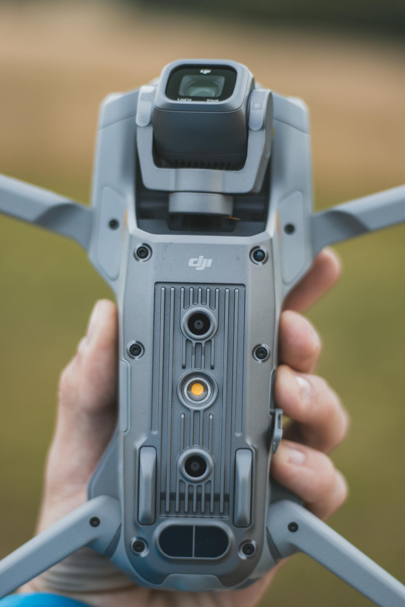 A close-up shot of a hand holding a gray drone outdoors in Liberec, Czech Republic.